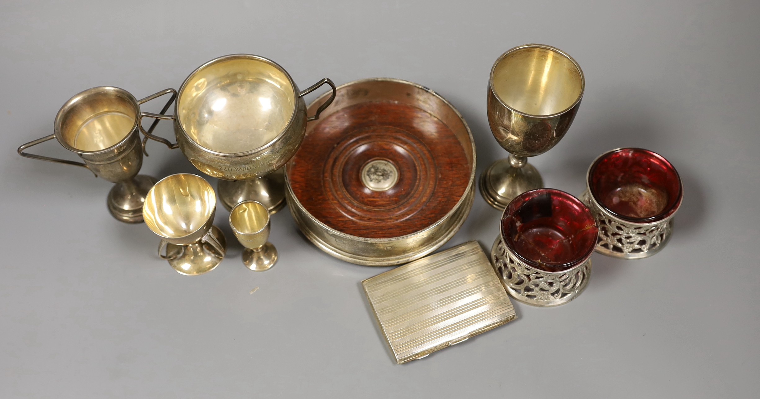 Sundry small silver including a modern wine coaster, a pair of Irish pierced silver salts(a.f.), two goblets, two small trophy cups and a cigarette case.